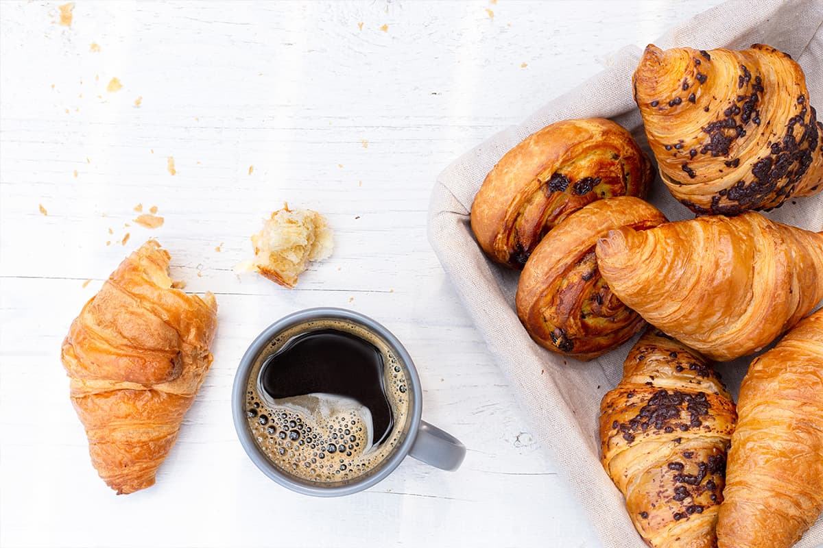 Continental breakfast display featuring fresh croissants, pastries, and coffee, available for morning meetings and events at Crooked Creek Golf Club.