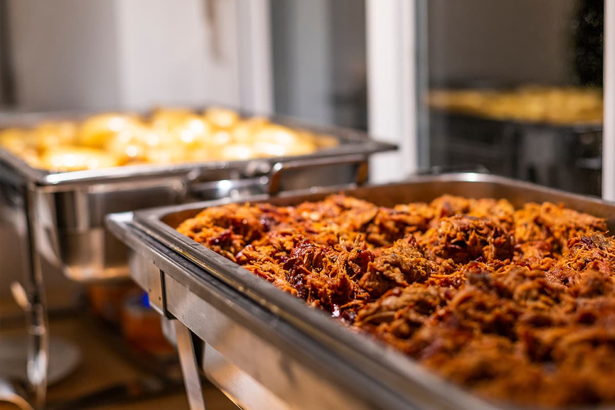 Buffet-style lunch service featuring slow-cooked entrées and hot side dishes, available for events at Crooked Creek Golf Club.